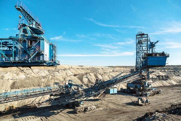 Mina a cielo abierto con maquinaria pesada de acero y cintas transportadoras para el tratamiento de minerales