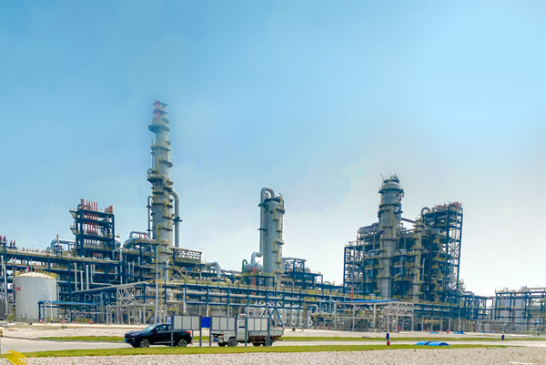 Vista de una gran planta petroquímica con columnas de destilación y un complejo sistema de tuberías de acero inoxidable